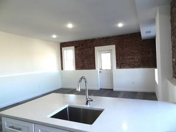 a kitchen with a sink and large mirror