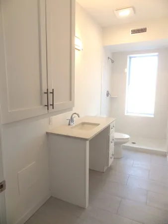 a bathroom with a double vanity sink toilet and a mirror