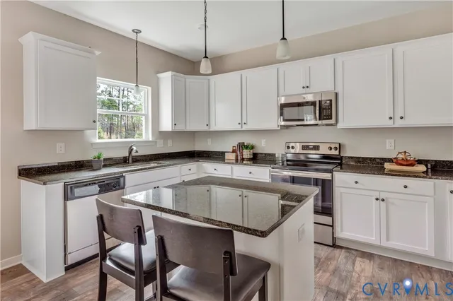 a kitchen with granite countertop white cabinets and white appliances