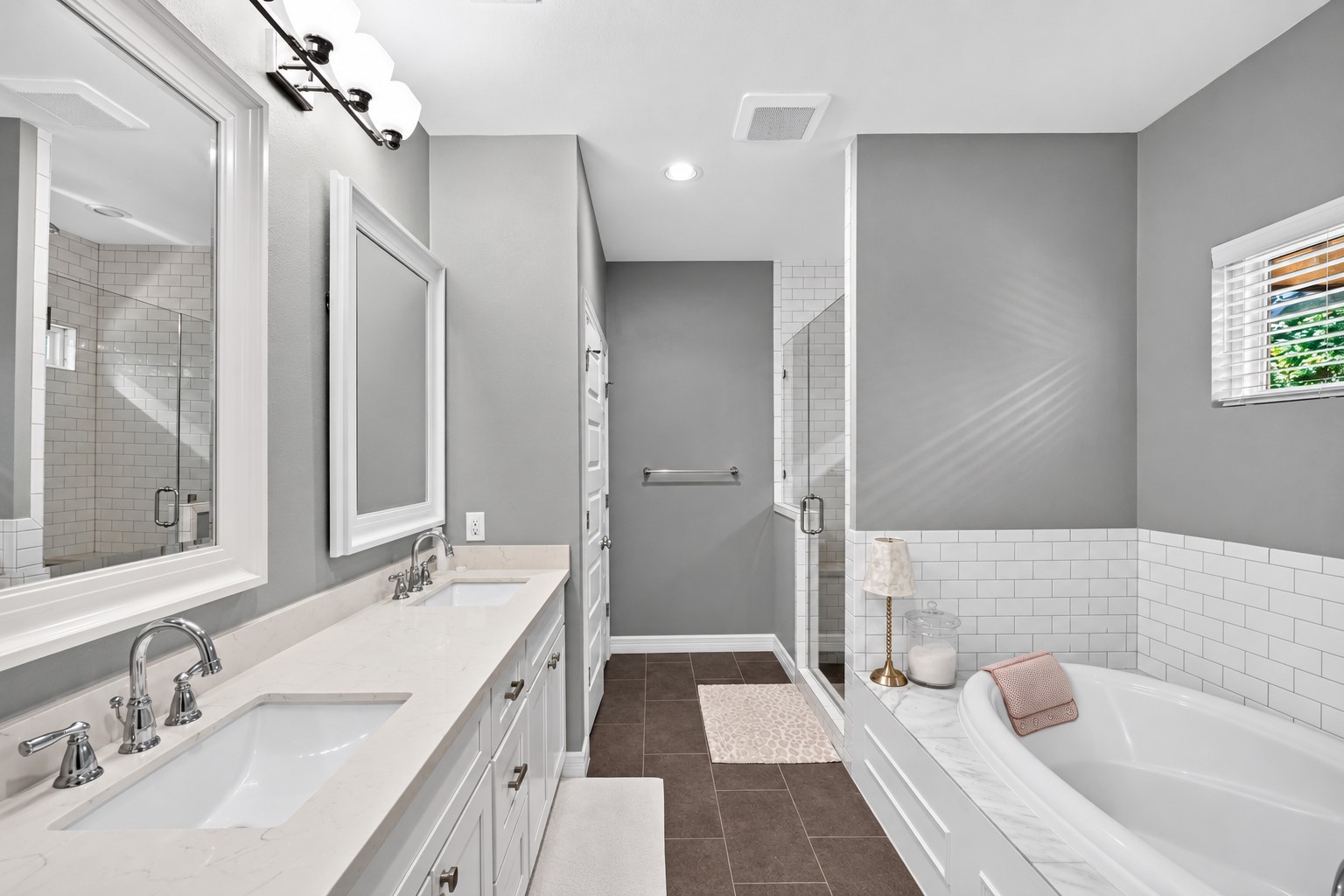 1722 Chippendale Road Houston, TX 77018 - Photo 19 of 41 Elegant primary bathroom featuring a spacious dual-sink vanity, luxurious soaking tub, and a glass-enclosed shower, all enhanced by modern lighting and sleek tile accents.