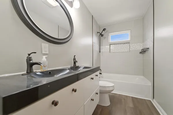 a bathroom with a granite countertop sink a toilet and a mirror