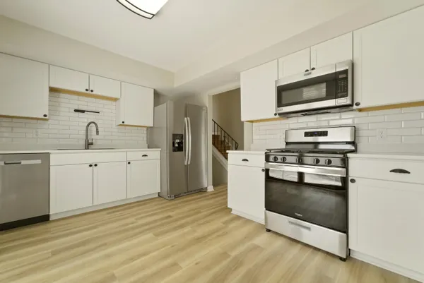a kitchen with stainless steel appliances a stove microwave and sink