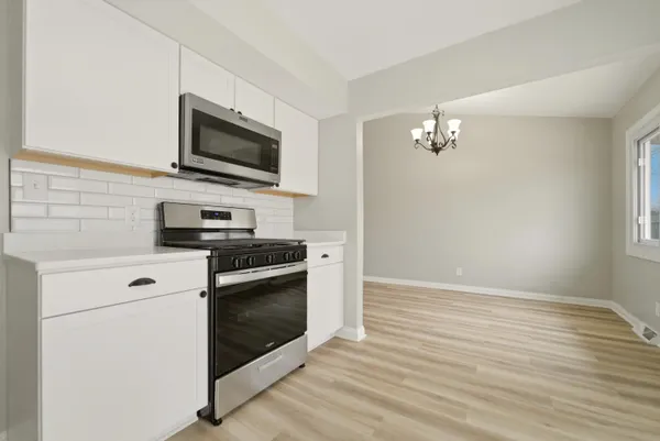 a kitchen with stainless steel appliances white cabinets and a stove