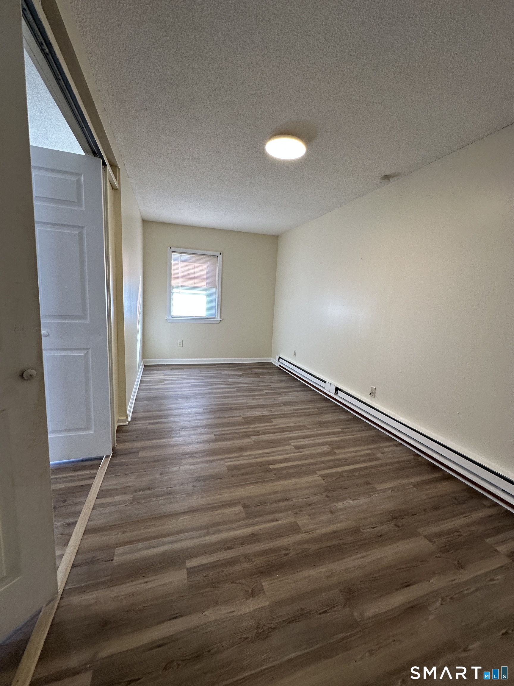 25-29 Locust Street New Britain, CT 06051 - Photo 2 of 5 an empty room with wooden floor and windows