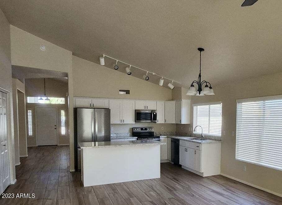 2642 South Augustine Mesa, AZ 85209 - Photo 4 of 18 a kitchen with stainless steel appliances granite countertop a refrigerator a sink dishwasher a stove and white cabinets with wooden floor