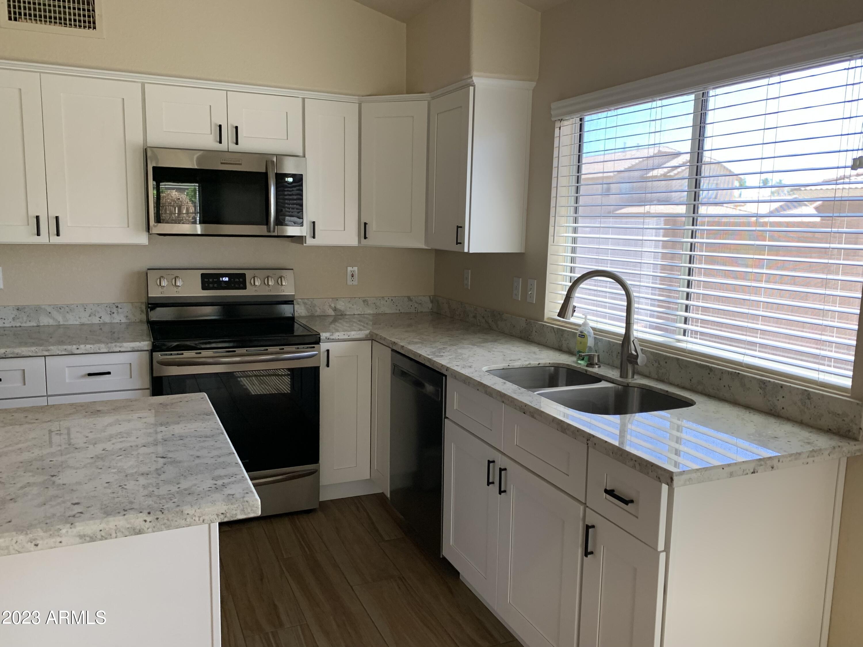 2642 South Augustine Mesa, AZ 85209 - Photo 5 of 18 a kitchen with granite countertop a sink and a stove top oven