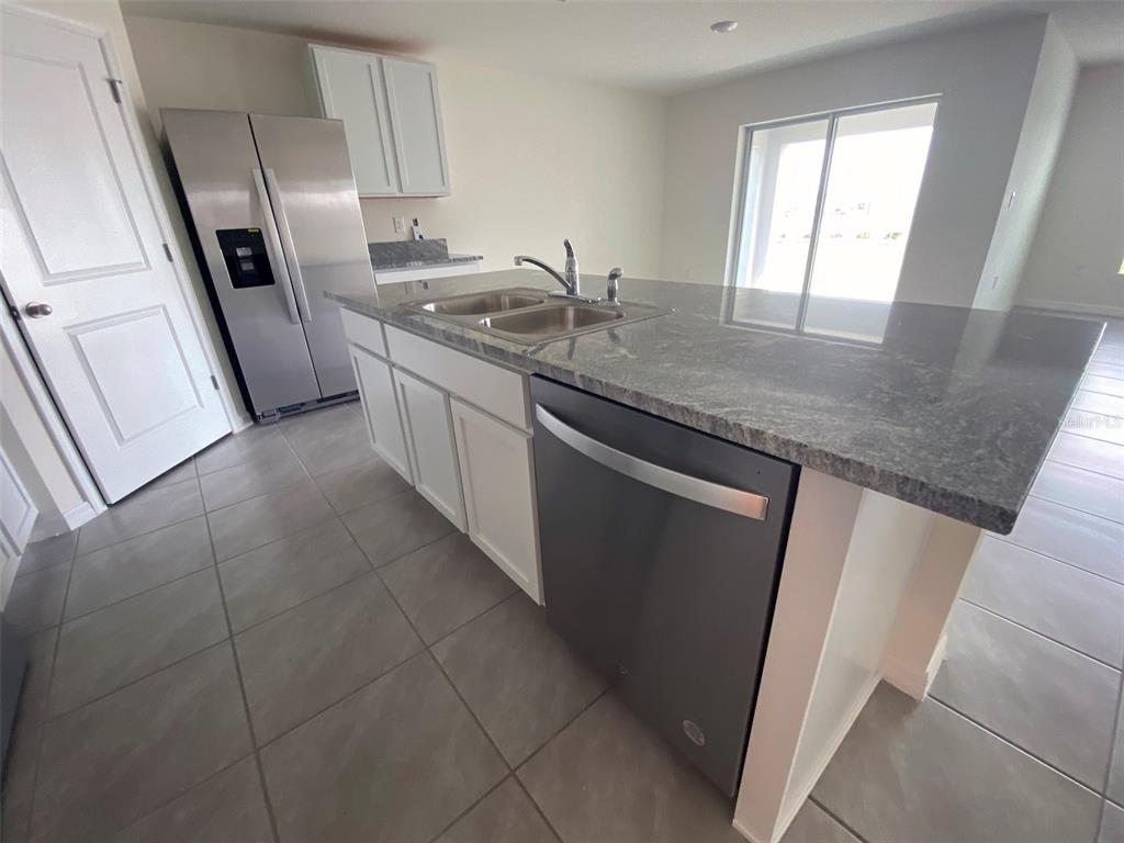 8864 Southwest 49th Circle Ocala, FL 34476 - Photo 16 of 48 a kitchen with stainless steel appliances granite countertop a sink stove and refrigerator