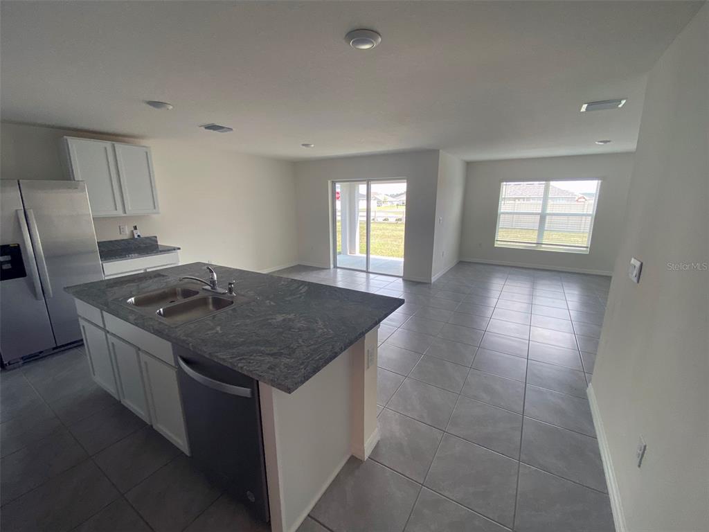 8864 Southwest 49th Circle Ocala, FL 34476 - Photo 21 of 48 a kitchen with granite countertop a sink stove and cabinets