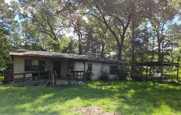 a view of a chair and table in backyard of the house