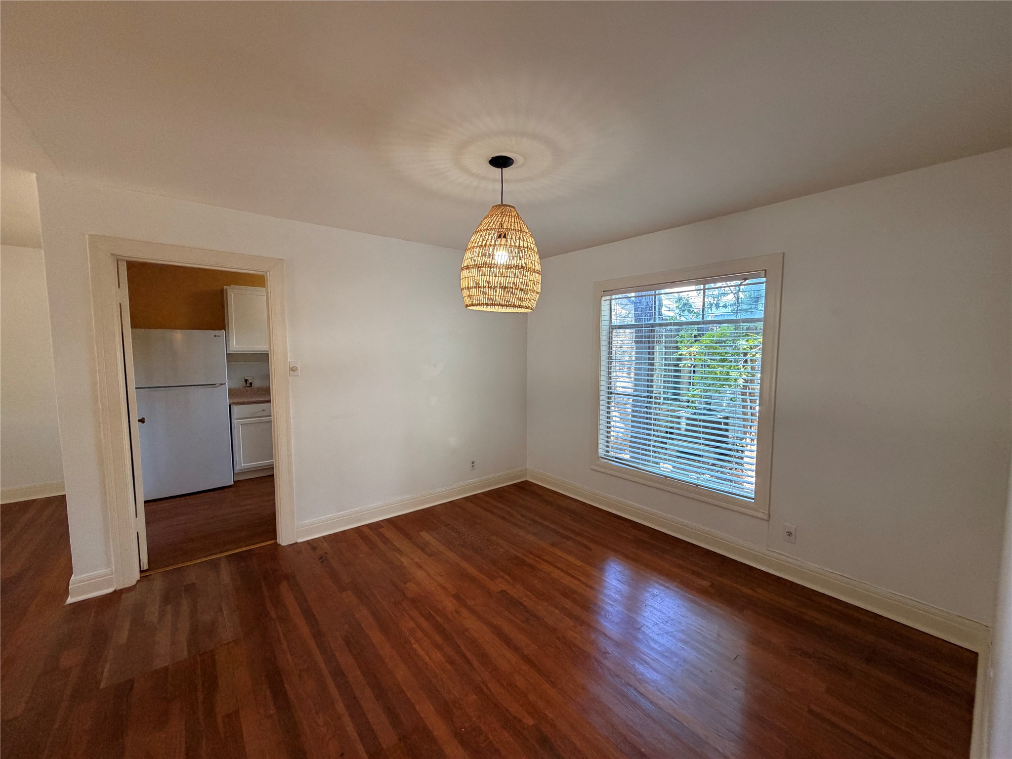 2511 Enfield Road, Unit A Austin, TX 78703 - Photo 3 of 7 Rich hardwood flooring extends through this well-lit dining space, complemented by a distinctive pendant light.