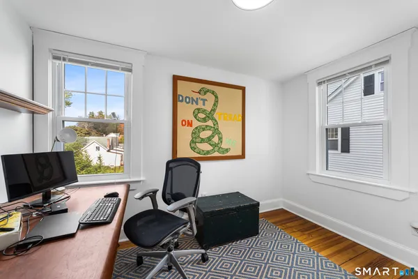 a view of a workspace with furniture and a window