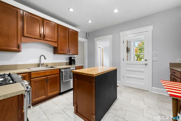 a kitchen with stainless steel appliances granite countertop wooden cabinets and sink