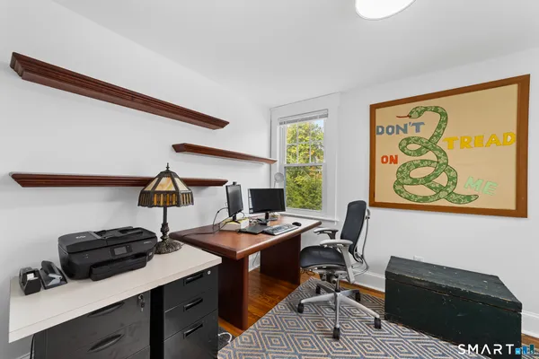 a view of a workspace with furniture and a window