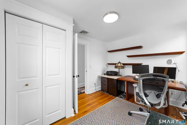 a view of a workspace with furniture and wooden floor
