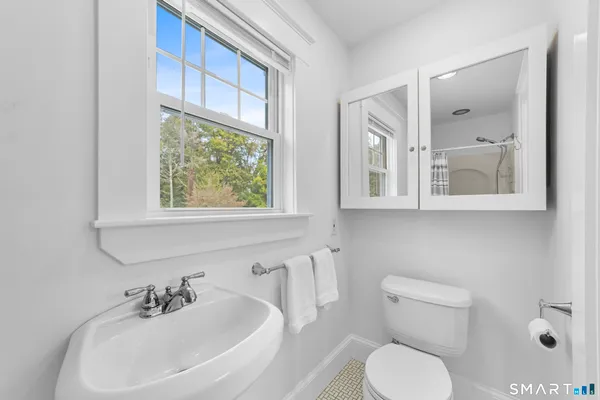 a bathroom with a toilet a sink and a large mirror
