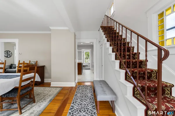 a view of a hallway with wooden floor and stairs