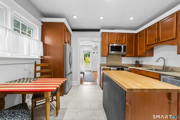 a kitchen with a sink a stove and chairs