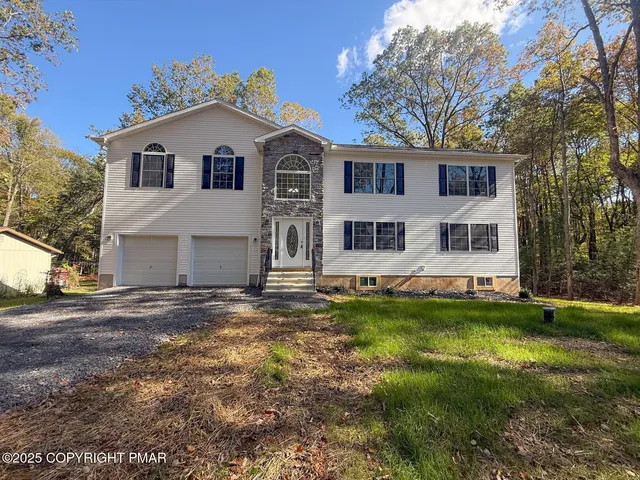a view of a white house with a big yard and large trees
