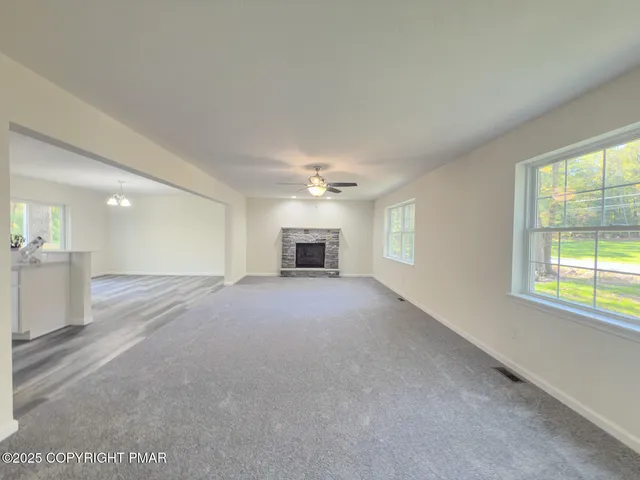 an empty room with a fireplace and windows
