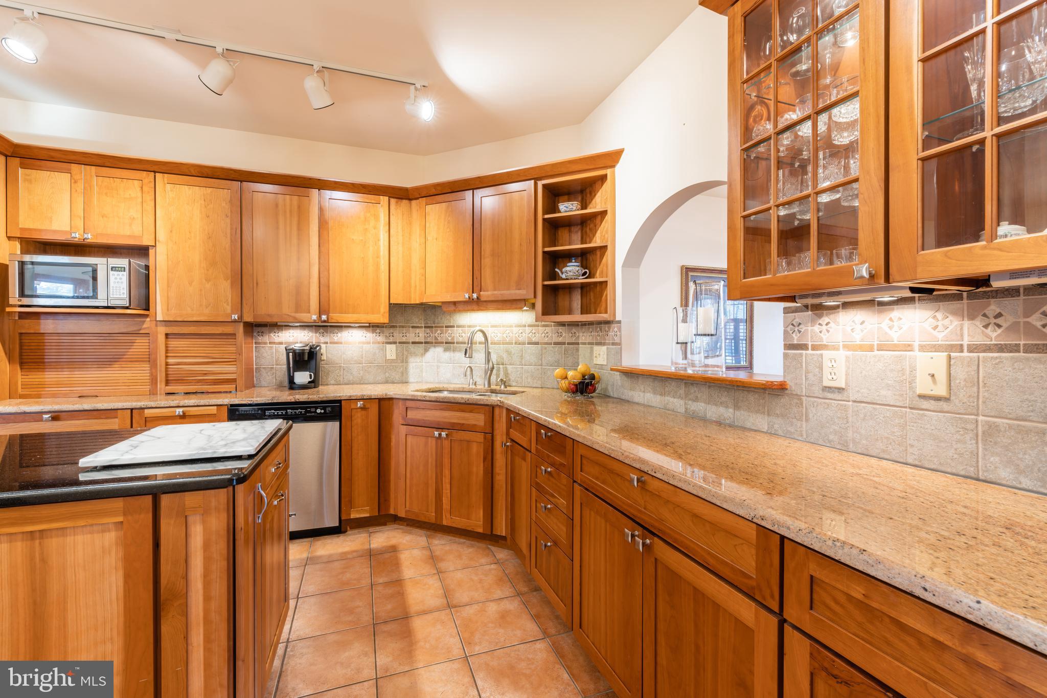 965 Curtis Road Solomons, MD 20629 - Photo 17 of 47 a kitchen with stainless steel appliances granite countertop sink stove and cabinets