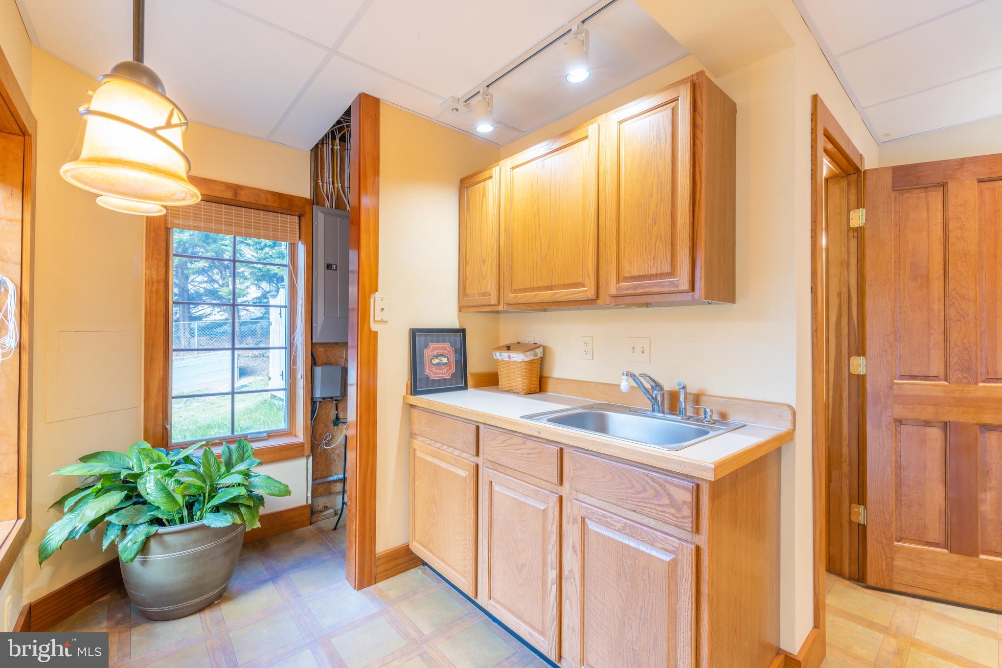 965 Curtis Road Solomons, MD 20629 - Photo 41 of 47 a kitchen with a sink a potted plant and a glass door