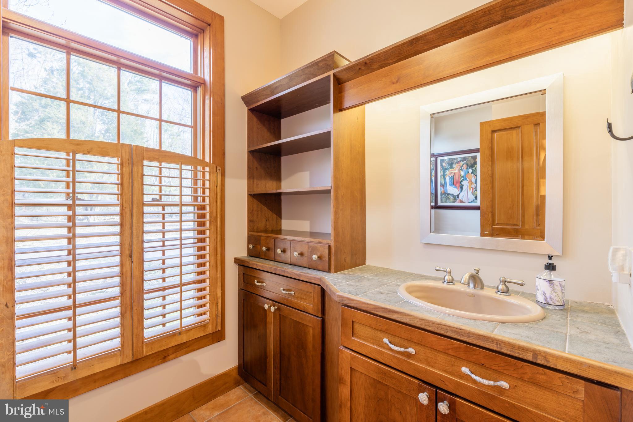 965 Curtis Road Solomons, MD 20629 - Photo 9 of 47 a bathroom with a granite countertop sink and a large mirror