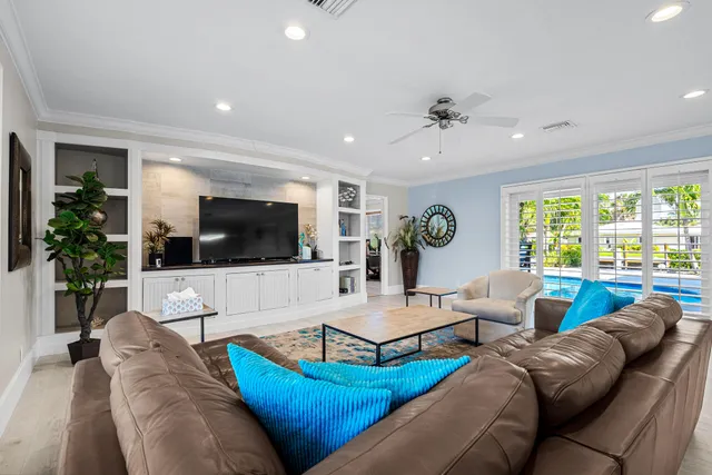 a living room with lots of furniture a rug and a view of kitchen