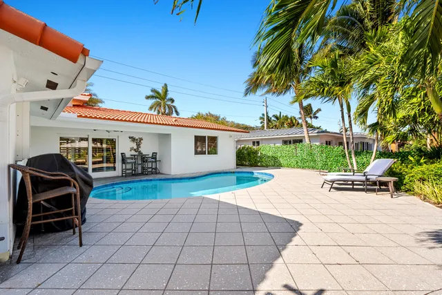 a view of a patio with table and chairs potted plants and palm tree