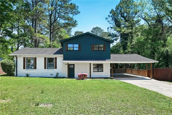 a front view of a house with yard and green space