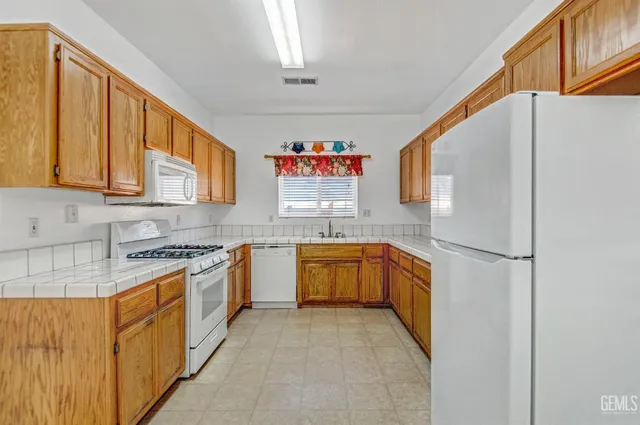 a kitchen with granite countertop stainless steel appliances a stove a sink and a refrigerator
