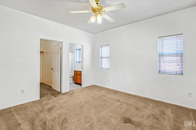 an empty room with closet and a chandelier fan