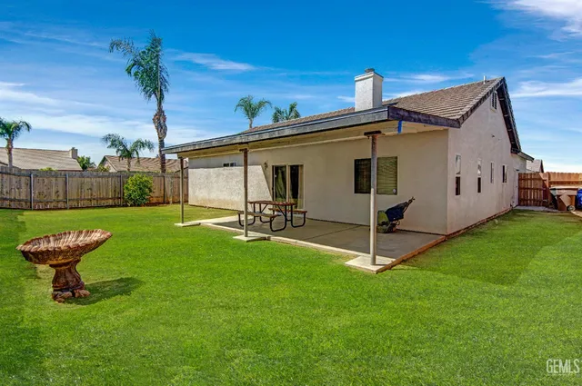 a view of a chair and table in backyard of the house
