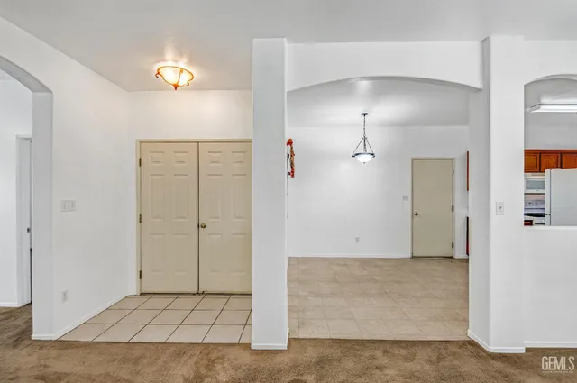 an empty room with cabinet and mirrors