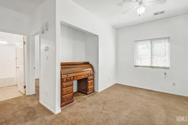 an empty room with windows and fireplace