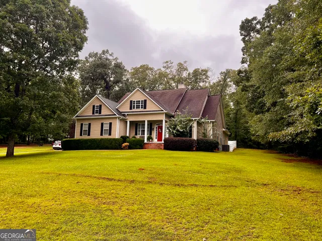 a front view of a house with yard and swimming pool