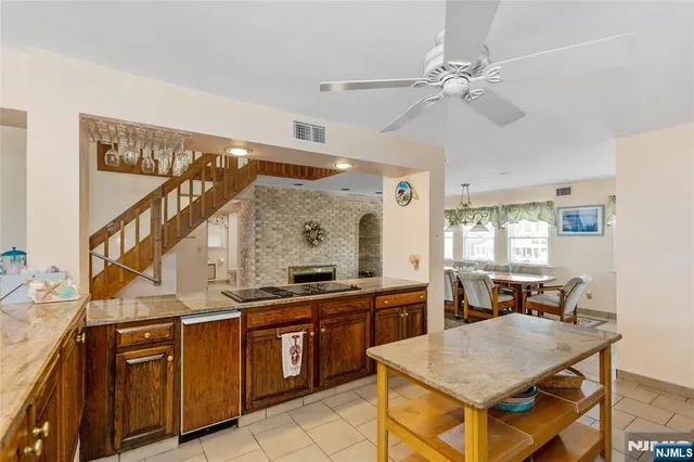 a open kitchen with a sink a stove and chairs
