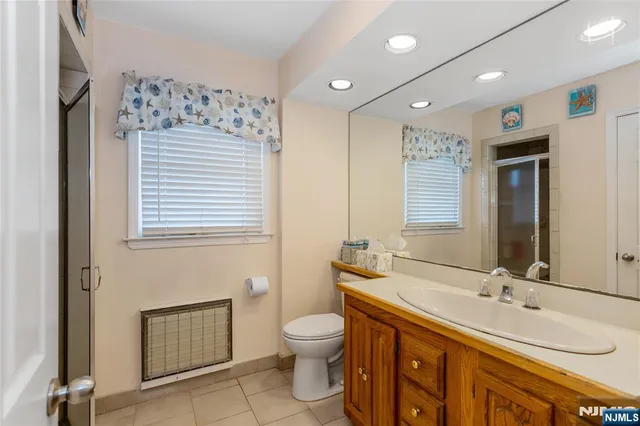 a spacious bathroom with a double vanity sink a toilet and a mirror