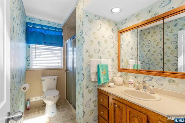 a bathroom with a sink a toilet and shower