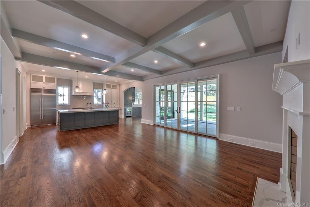 724 Ellsworth Road Charlotte, NC 28211 - Photo 4 of 33 a view of an empty room with wooden floor and a kitchen