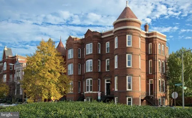 front view of a brick house with a yard