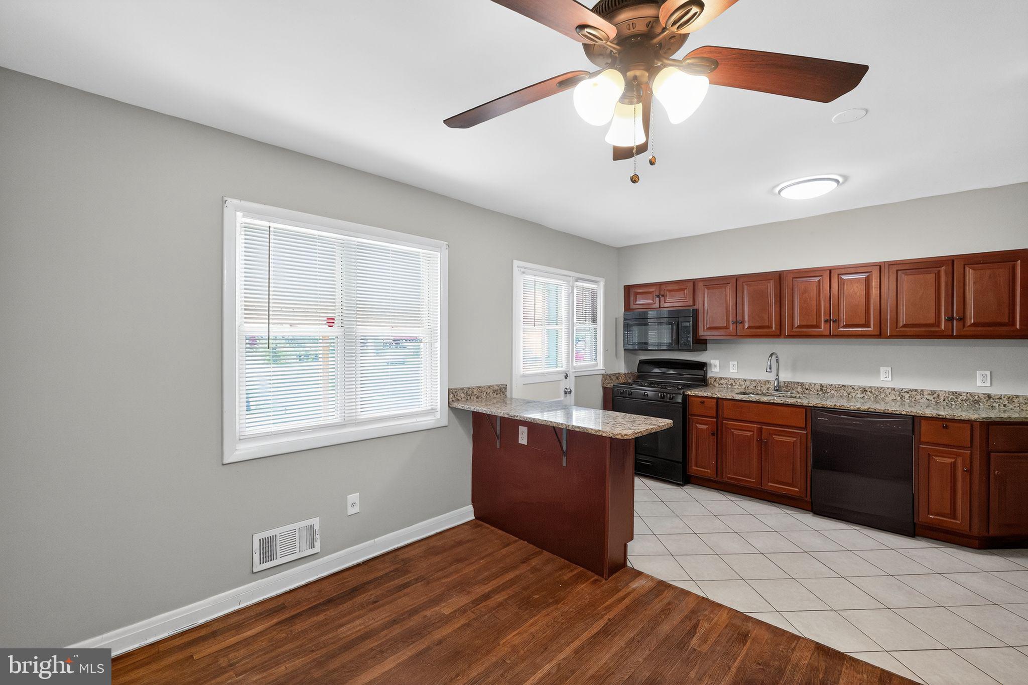 3125 Vulcan Road Dundalk, MD 21222 - Photo 16 of 33 a kitchen with stainless steel appliances granite countertop a sink dishwasher stove and refrigerator with wooden floor