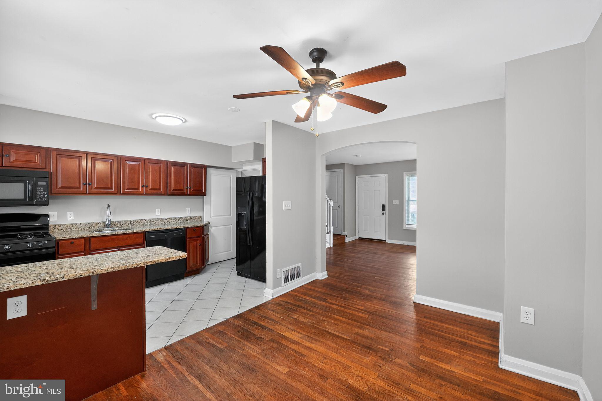 3125 Vulcan Road Dundalk, MD 21222 - Photo 22 of 33 a view of an empty room and kitchen with wooden floor