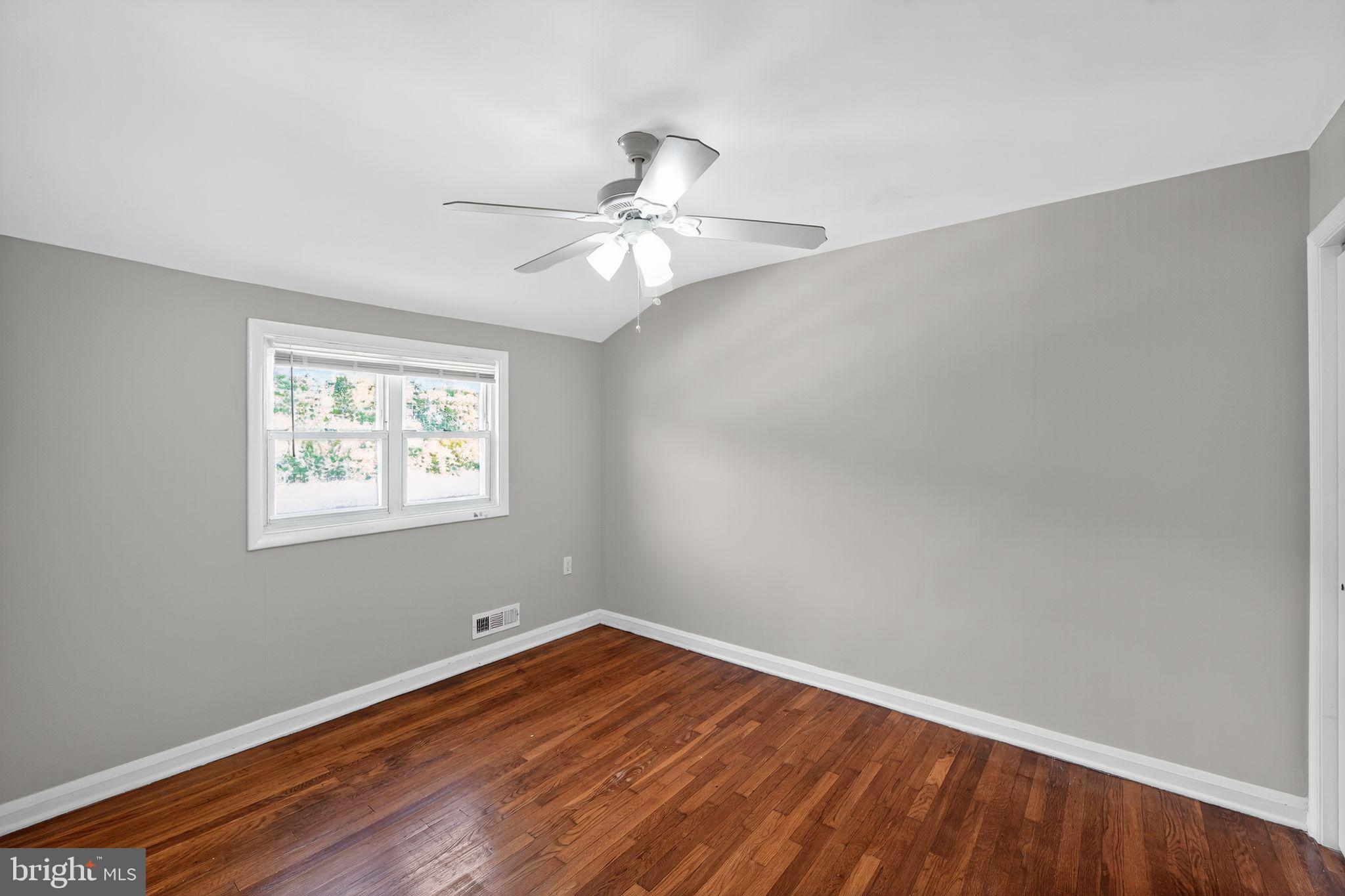 3125 Vulcan Road Dundalk, MD 21222 - Photo 9 of 33 an empty room with wooden floor fan and windows