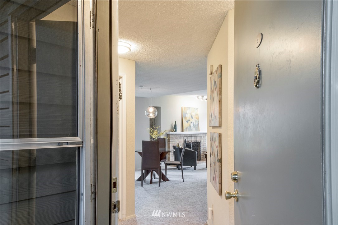 118 Southwest 116th Street, Unit D21 Seattle, WA 98146 - Photo 2 of 17 a view of a hallway with dining area and glass door