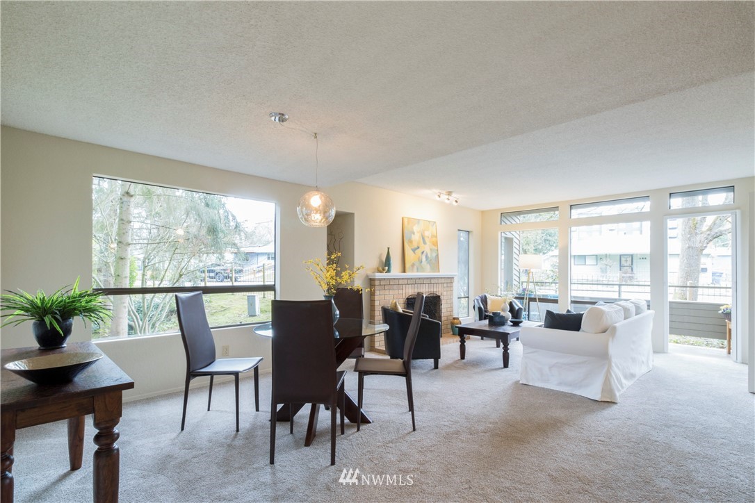 118 Southwest 116th Street, Unit D21 Seattle, WA 98146 - Photo 3 of 17 a living room with furniture floor to ceiling windows and a table