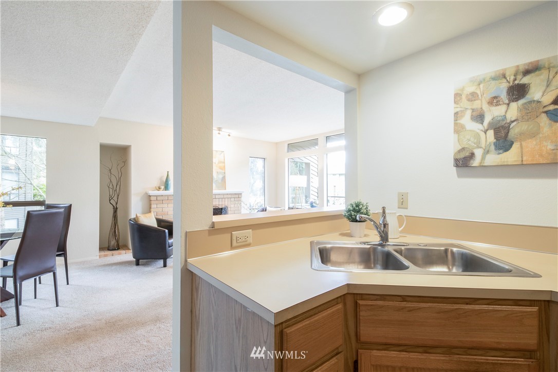 118 Southwest 116th Street, Unit D21 Seattle, WA 98146 - Photo 6 of 17 a kitchen that has a sink and a table in it