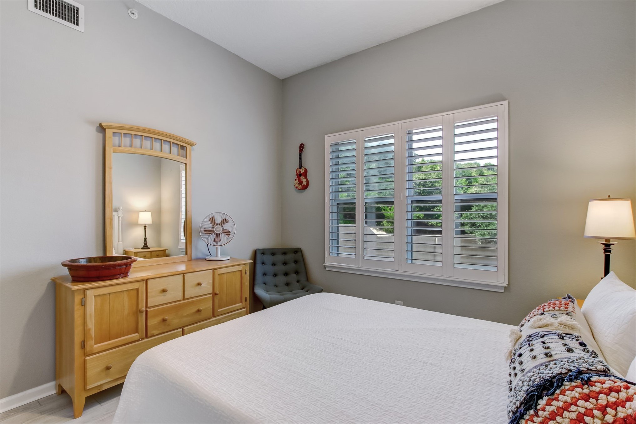 403 Tarpon Avenue, Unit 101 Fernandina Beach, FL 32034 - Photo 21 of 36 a bedroom with a bed and a lamp on dresser