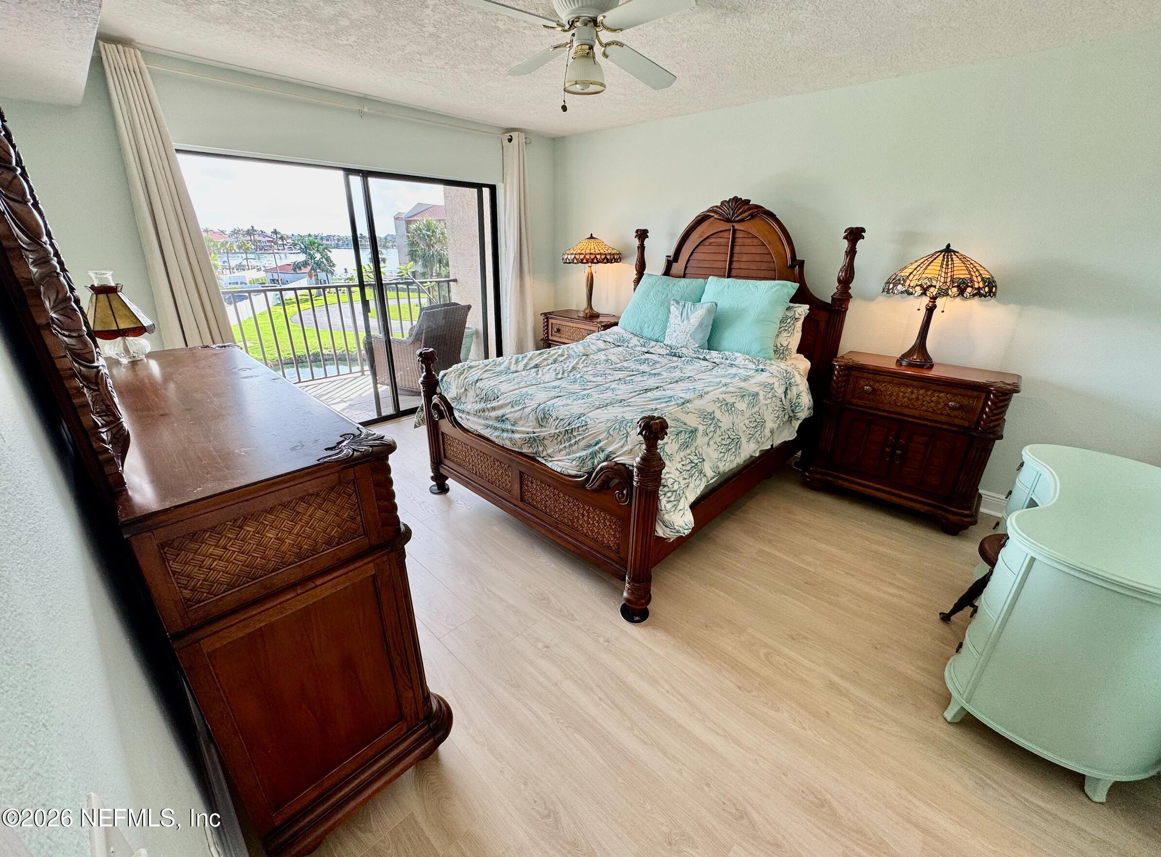 8711 Blind Pass Road, Unit 208A St. Petersburg, FL 33706 - Photo 13 of 21 a bedroom with a bed chair and a large window