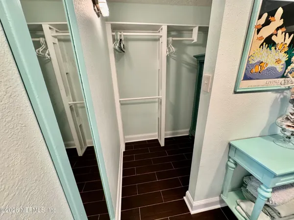 a view of walk in closet with wooden floor