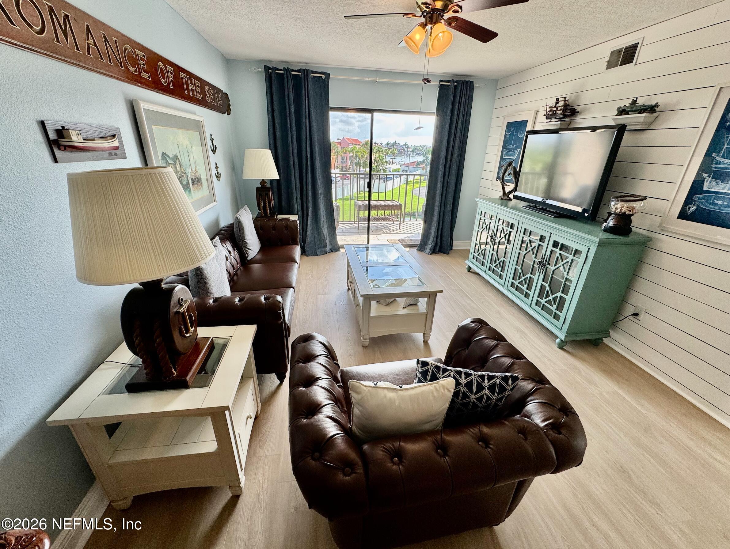 8711 Blind Pass Road, Unit 208A St. Petersburg, FL 33706 - Photo 8 of 21 a living room with furniture and a flat screen tv